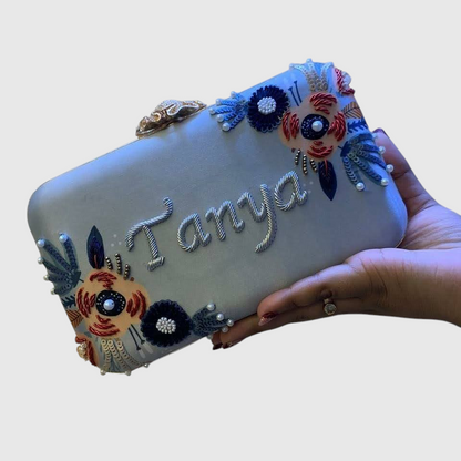 Cannish Pitara personalized light blue clutch with Tanya name embroidery, floral beadwork, and metallic clasp.
